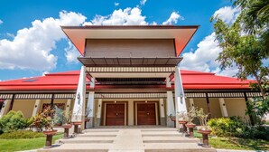 A building with a red roof, two large wooden doors, and a covered entrance area. - Goldenland Resort (Chok Chai)