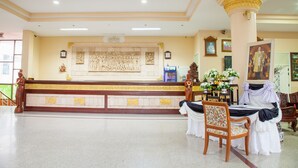 A reception area with a marble counter, a large wall mural, and a reception desk. - Goldenland Resort (Chok Chai)