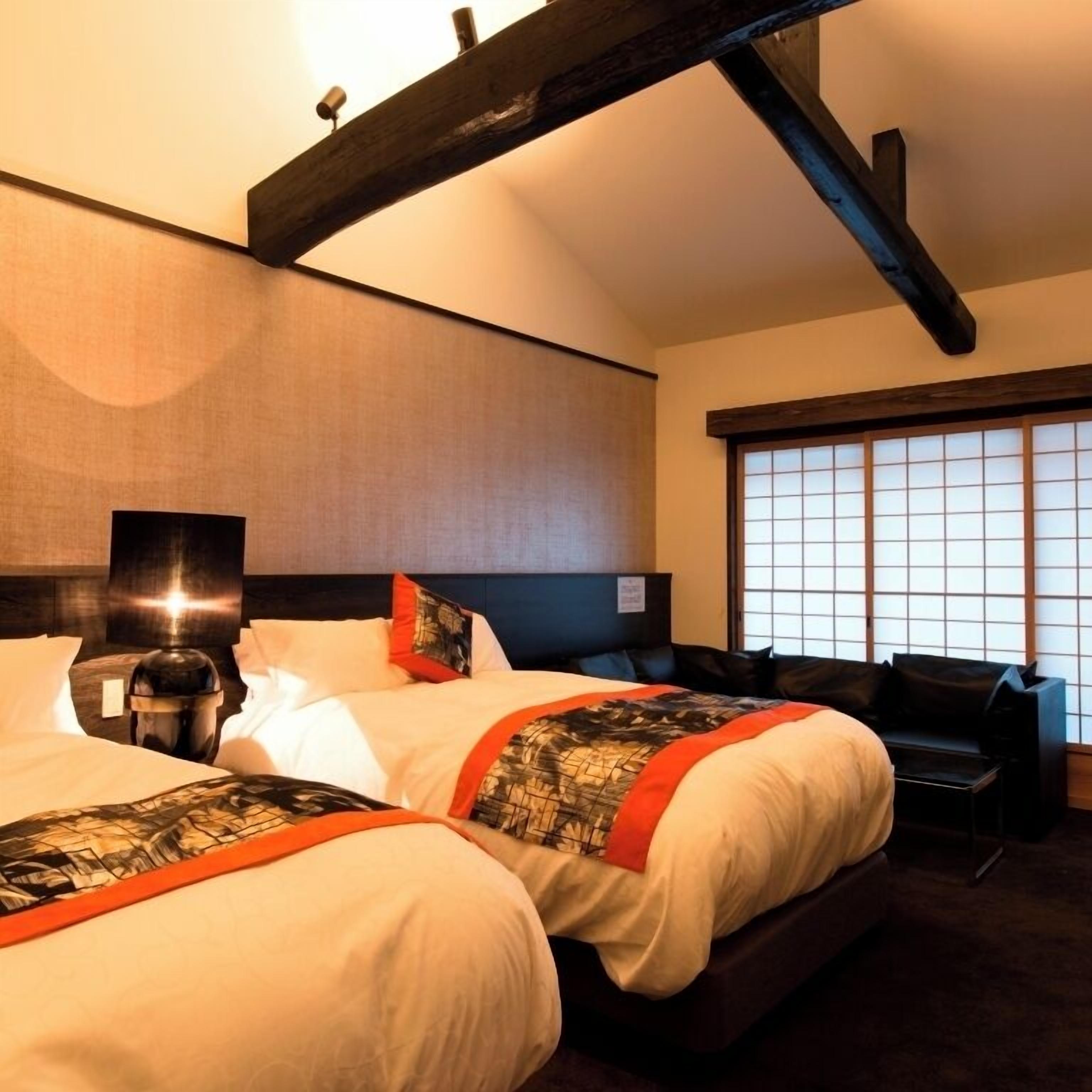 Quarto de hotel com uma cama grande, uma escrivaninha e vista para o exterior pela janela.