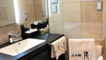 A modern bathroom with a large mirror, a sink, and a towel rack.