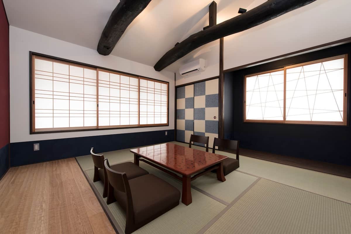 A traditional Japanese-style room with tatami flooring, a low wooden table, and shoji screens.