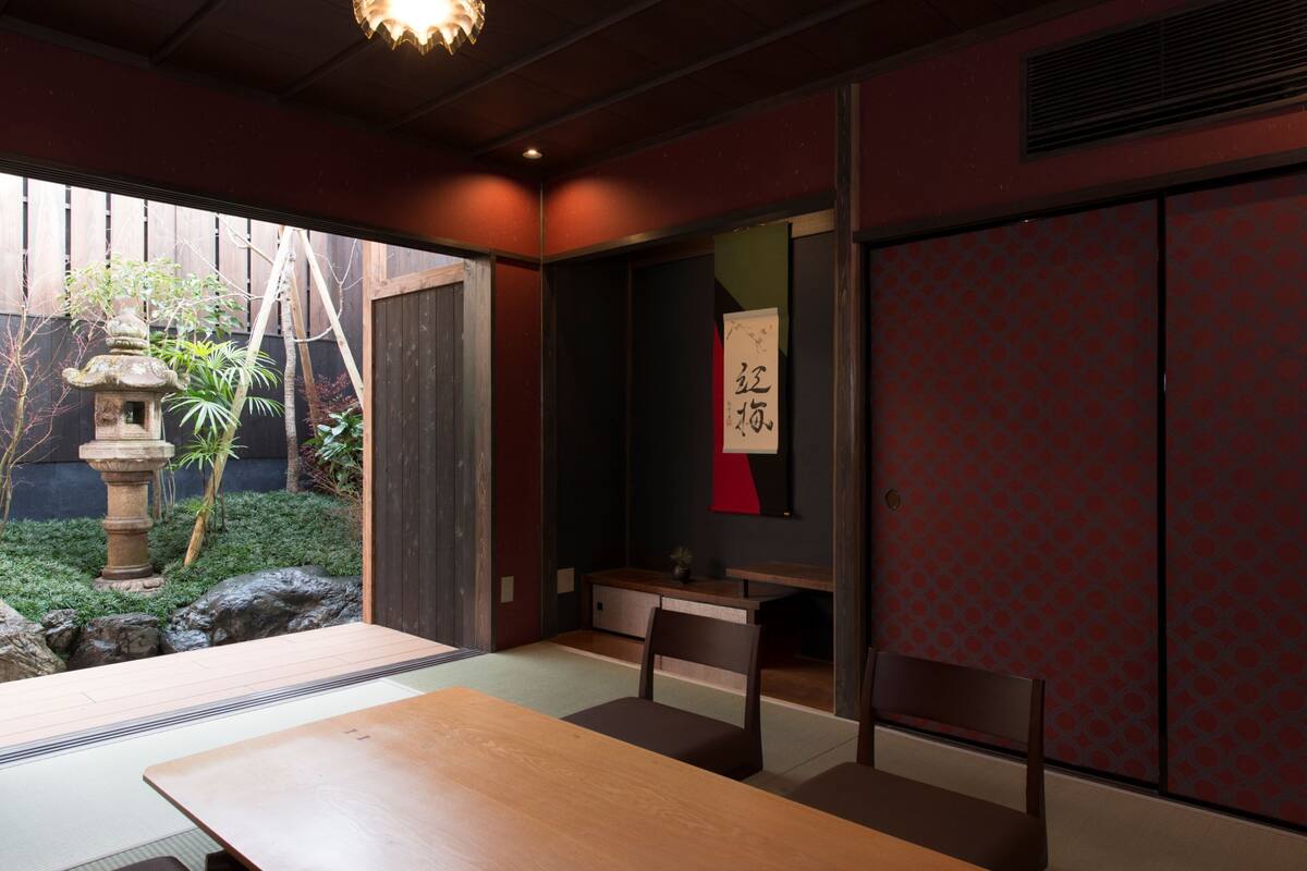 A traditional Japanese room with tatami flooring, a low table, and a sliding door.