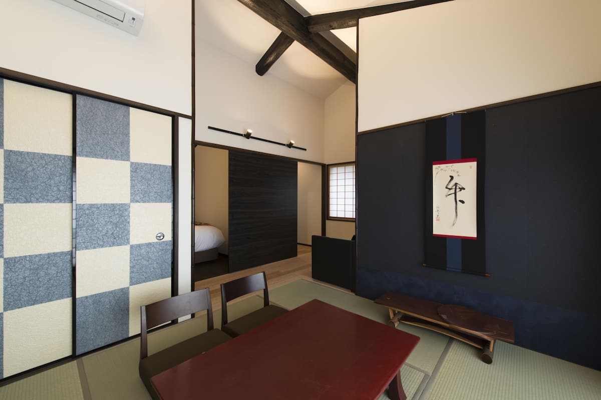 A traditional Japanese room with tatami flooring, a low wooden table, and a shoji screen.