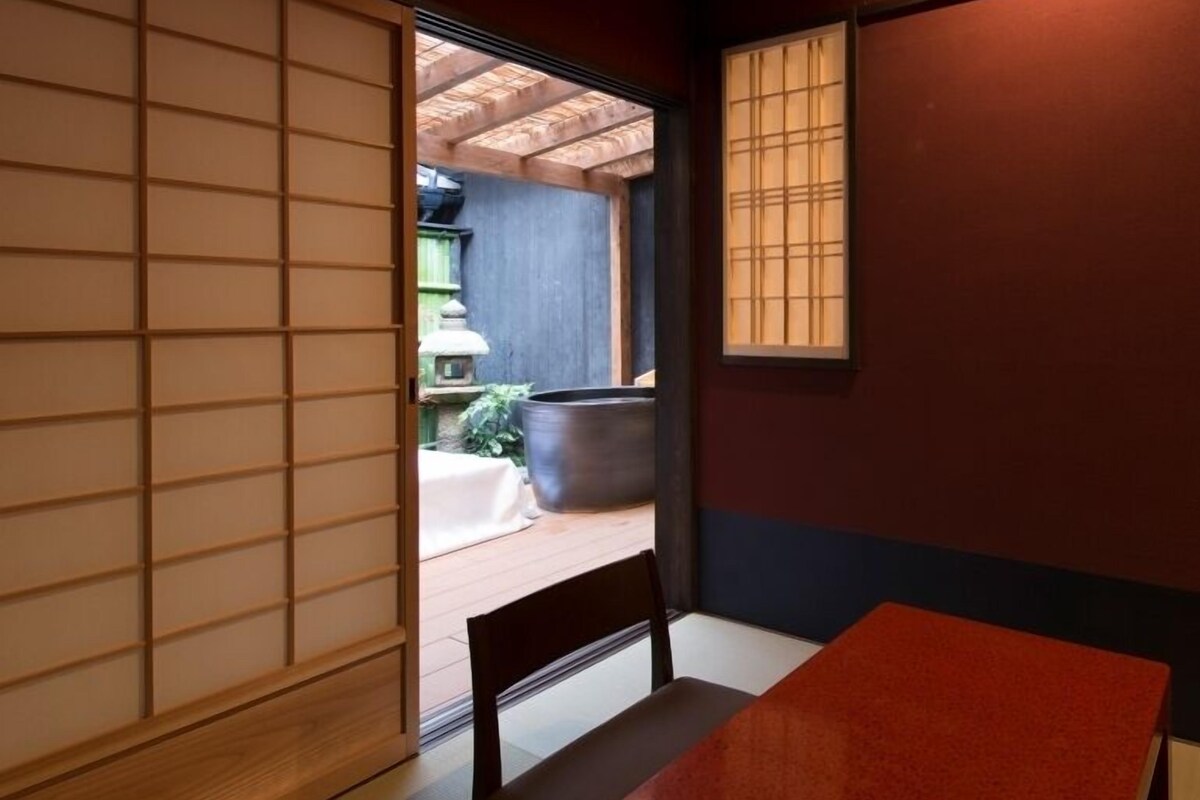 Ett traditionellt japanskt rum med tatamimattor på golvet, ett lågt bord och skjutdörrar.