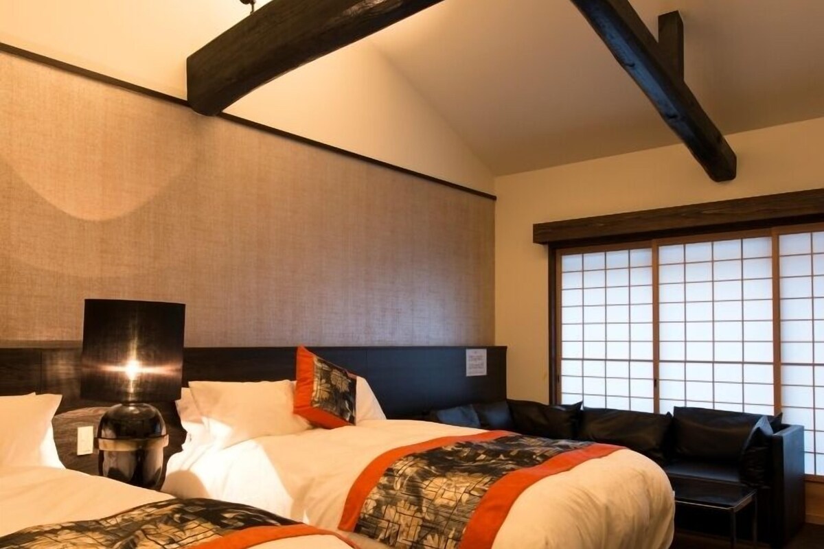 Ett hotellrum med två sängar, ett skrivbord och ett stort fönster med utsikt.
