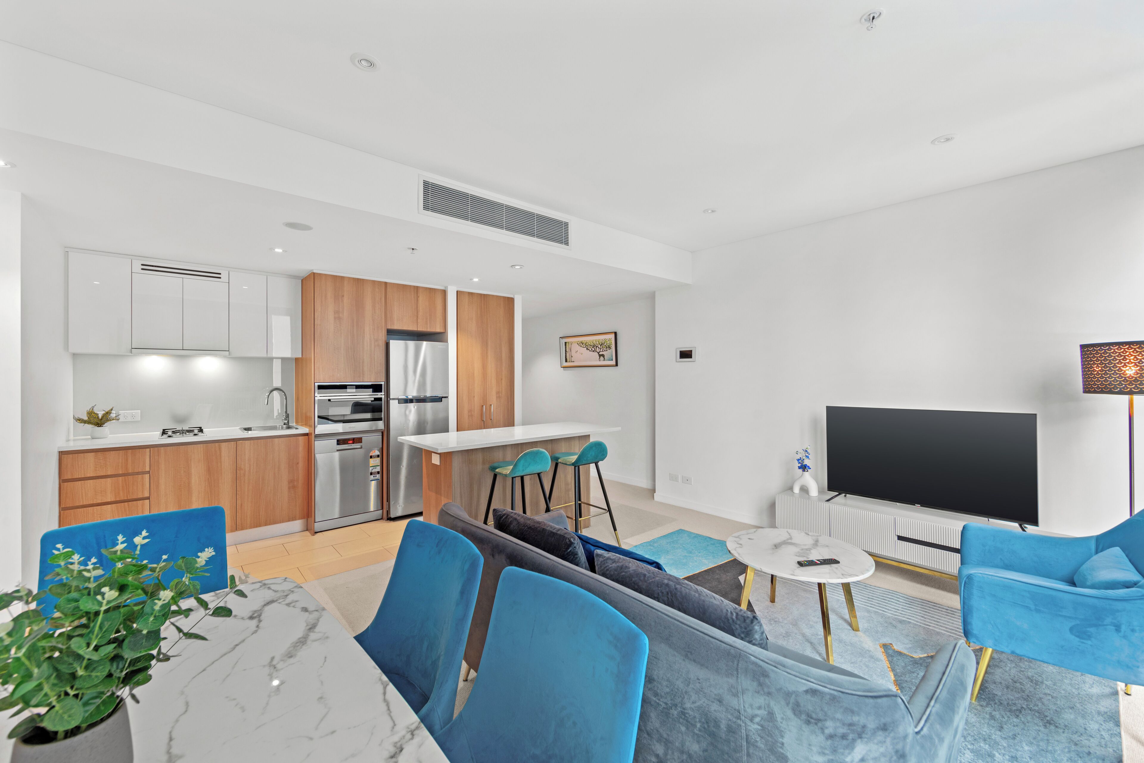 A modern apartment with a kitchen, dining area, and living room.