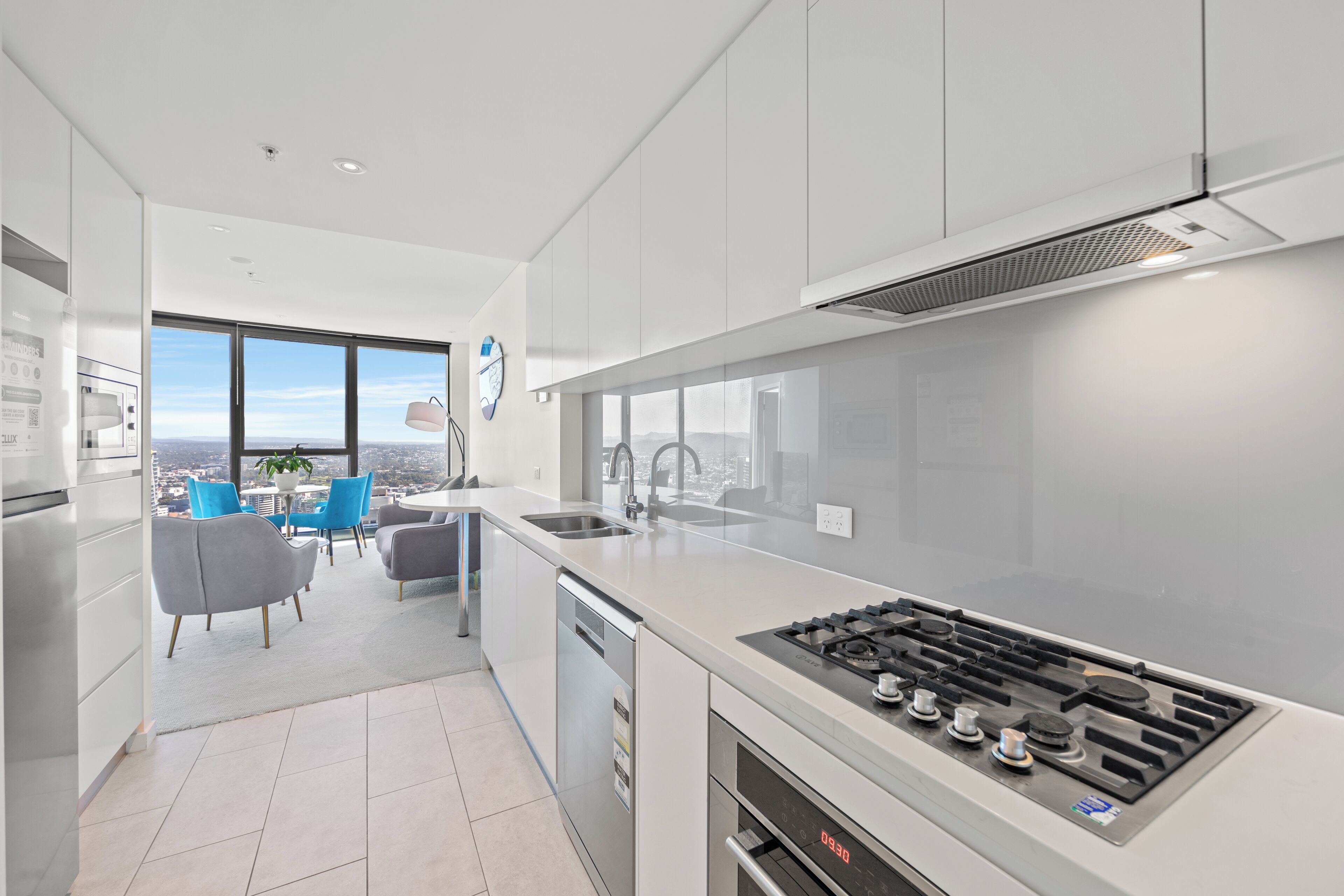 A modern kitchen with a large window, a dishwasher, and a gas stove.