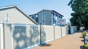 A fenced pathway leading to a Horizon Inn building with a sign indicating bed and breakfast services. - Horizon Inn (Harare)