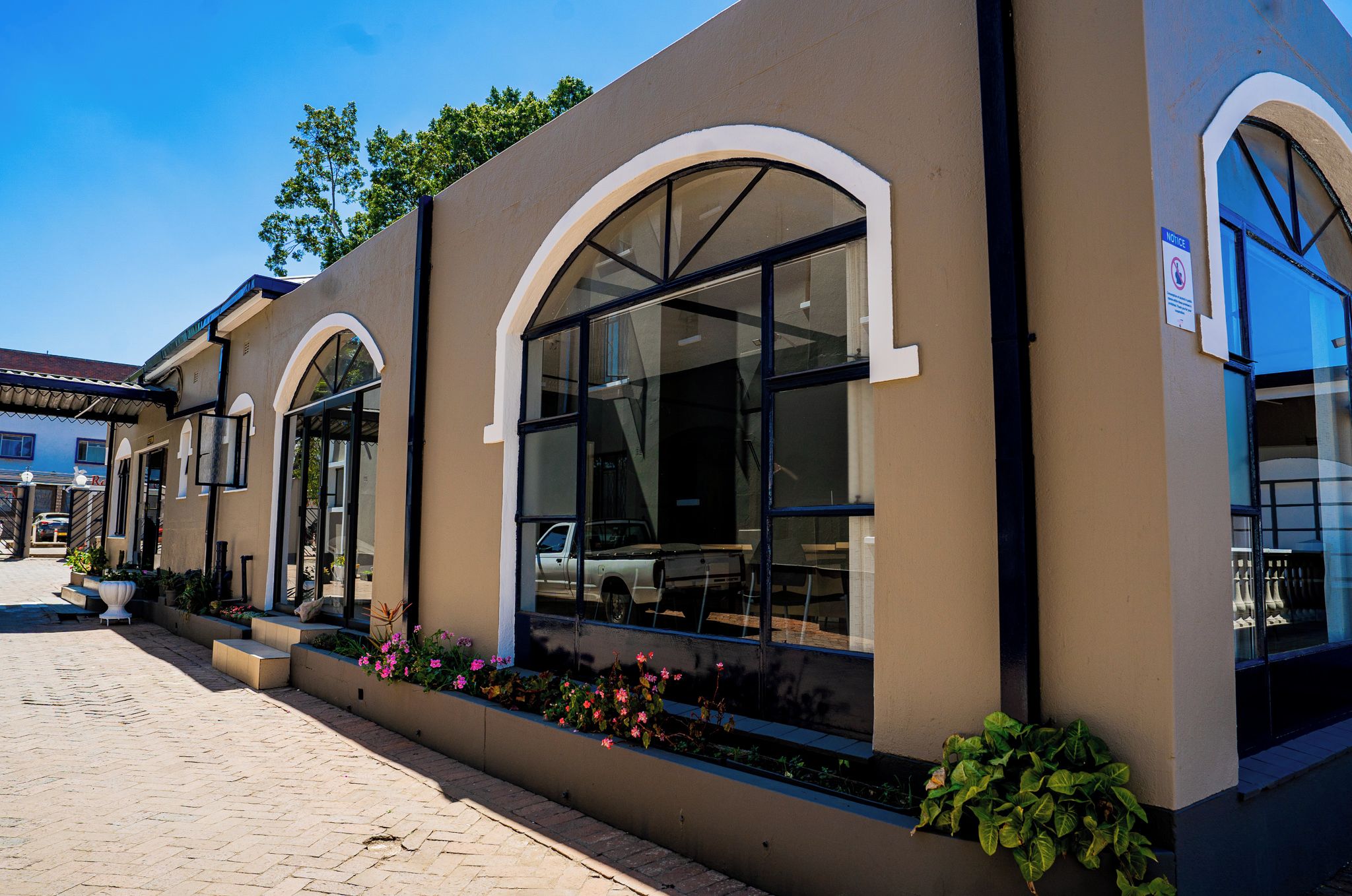 A building with arched windows and a paved walkway.