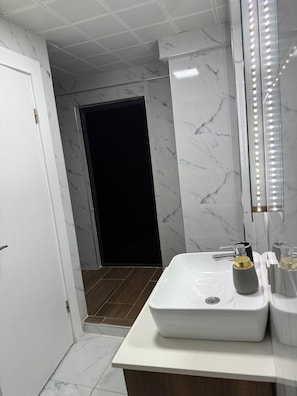 Apartamento luxo | Banheiro | Chuveiro, chuveiro com efeito de chuva, secador de cabelo, chinelos