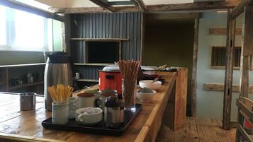 A kitchen with wooden beams, a stove, and various cooking utensils.