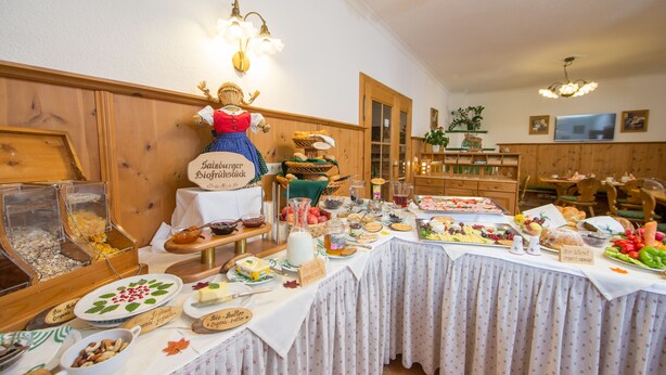 A buffet table with various food items and a decorative figure. - Pension Hubertus (Zell am See)