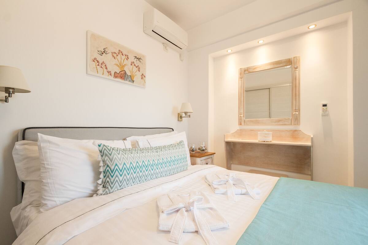 Ein Hotelzimmer mit Bett, Nachttisch, Spiegel und Wandklimaanlage.