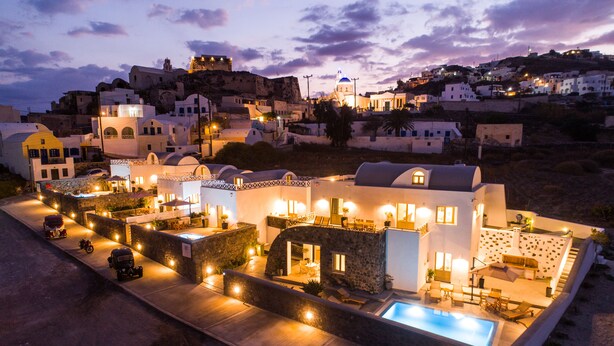 Une villa moderne dotée d’une piscine, d’un espace salon extérieur et offrant une vue sur la ville environnante.