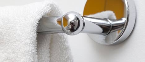 A white towel hanging on a chrome towel bar.