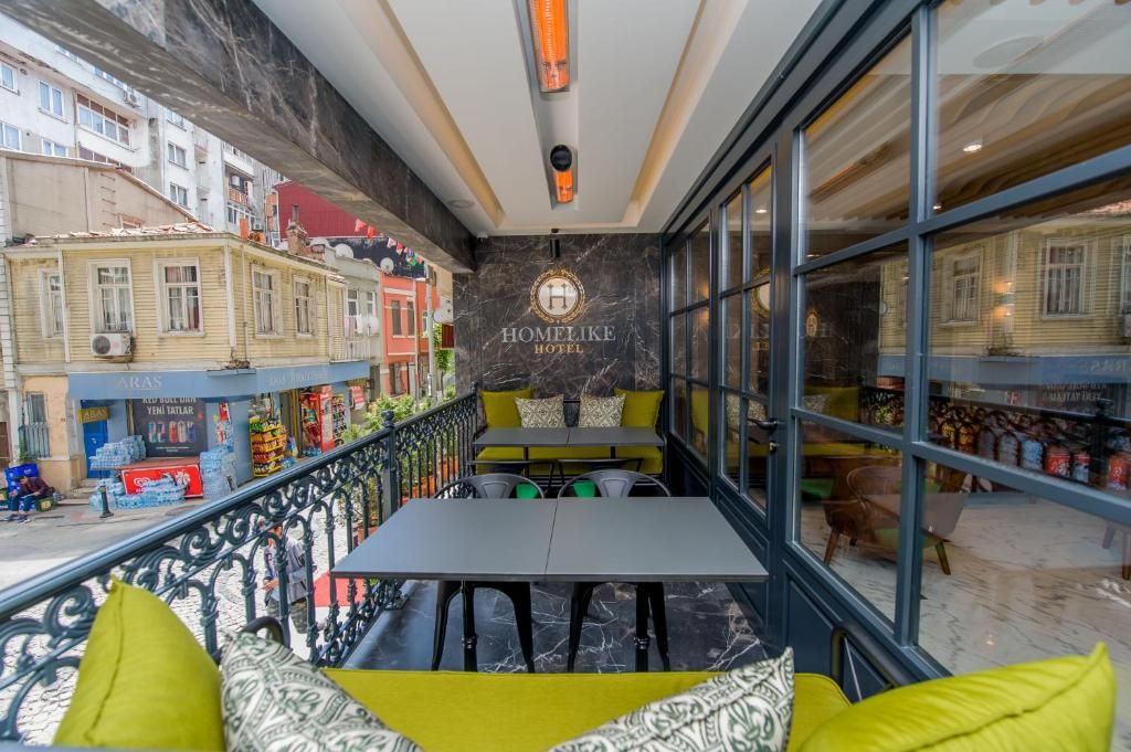 A hotel balcony with seating, a view of the street, and a marble wall with the hotel's name.