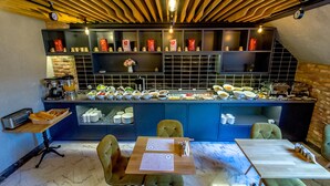 A breakfast bar with a variety of food items and a seating area with tables and chairs. - Homelike Hotel (Istanbul)