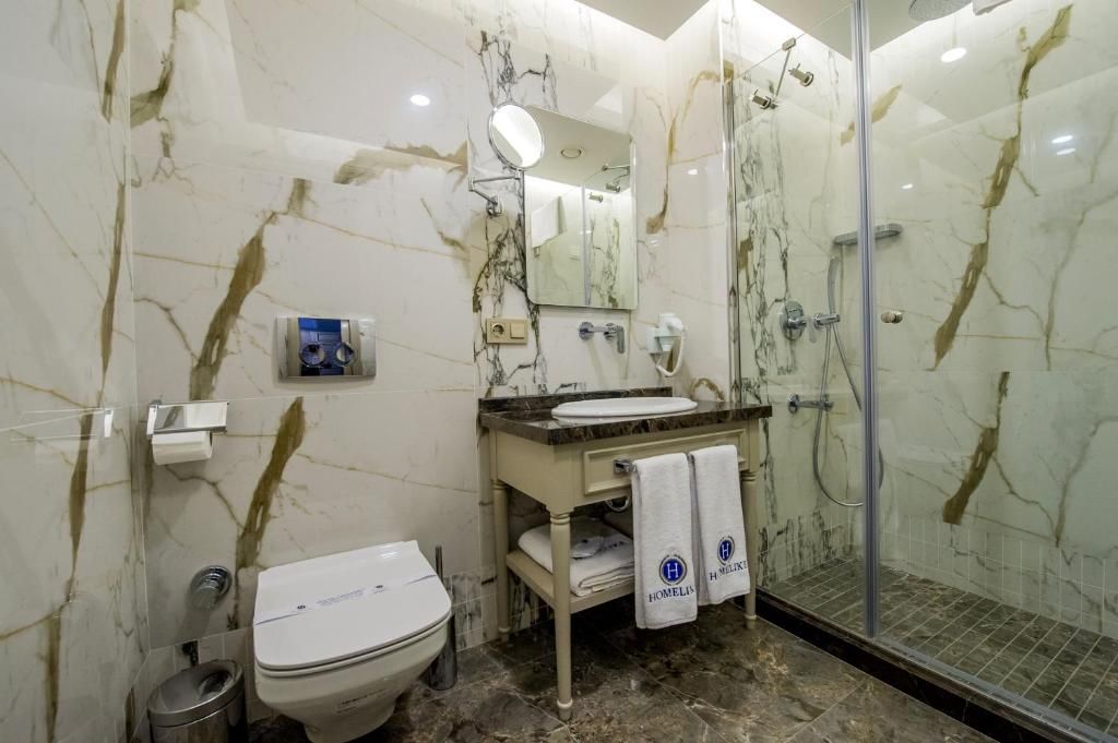Un baño con inodoro, lavamanos, espejo y ducha.