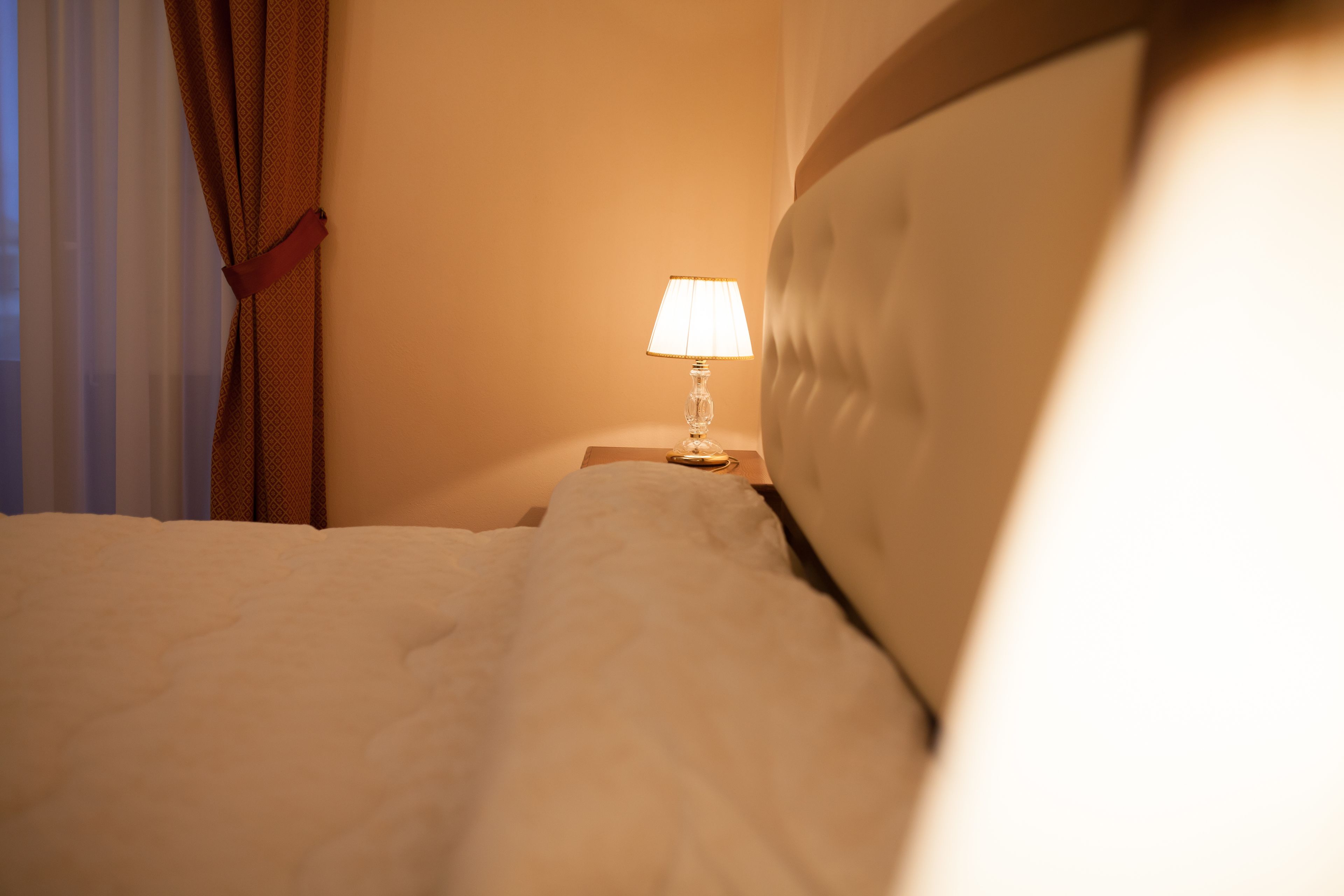 Ein Hotelzimmer mit einem Bett, einem Nachttisch und einer Lampe.