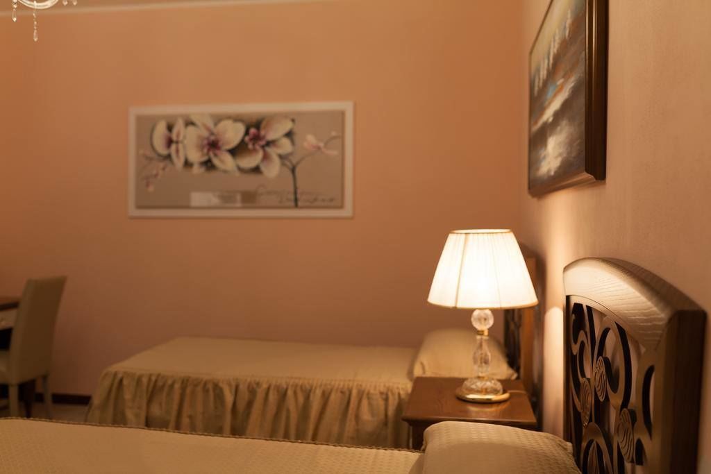 Une chambre d’hôtel avec un lit, une table de chevet avec une lampe et un tableau au mur.