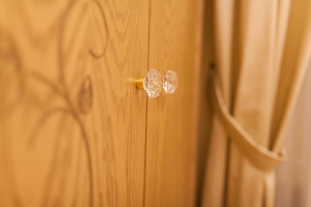 Une porte en bois avec un bouton de porte en laiton et une poignée en verre.