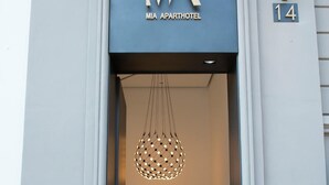 The entrance to Mia Apartments with a modern design, including a unique spherical light fixture and a staircase leading inside. - Gatto Bianco Mia Aparthotel (Milan)