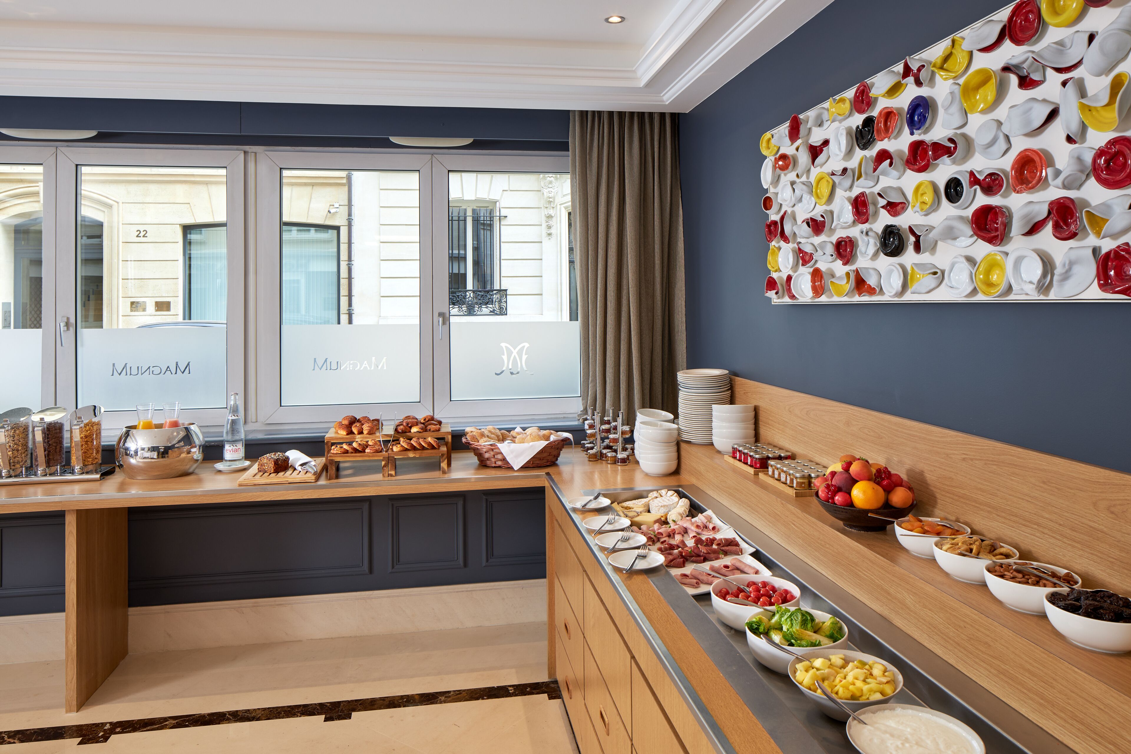 Un buffet de petit-déjeuner proposant une variété de plats et une installation artistique murale.