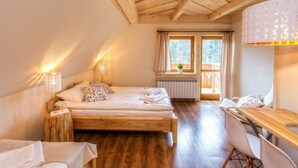 A cozy bedroom with a wooden bed, a desk, and a window with curtains. - Willa Giewontka (Koscielisko)
