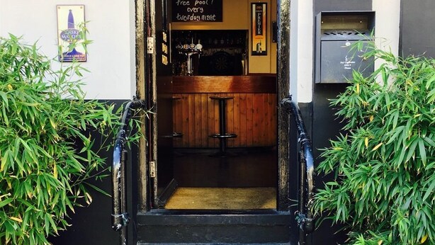 Eine Treppe führt zu einem Barbereich, wo ein Schild auf kostenlosen Zugang zum Billardtisch an jedem Abend hinweist.