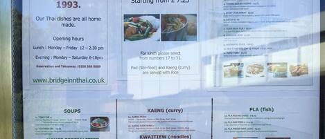 Un menu de restaurant thaïlandais présentant divers plats, notamment des entrées, des soupes et des plats principaux.