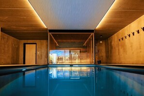 Una piscina techada, sillones reclinables de piscina
