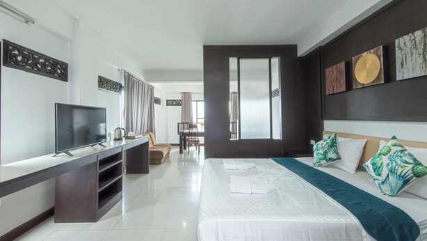 A modern hotel room with a large bed, a TV, a desk, and a view of the dining area. - The Wing Design Hotel (Bangkok)