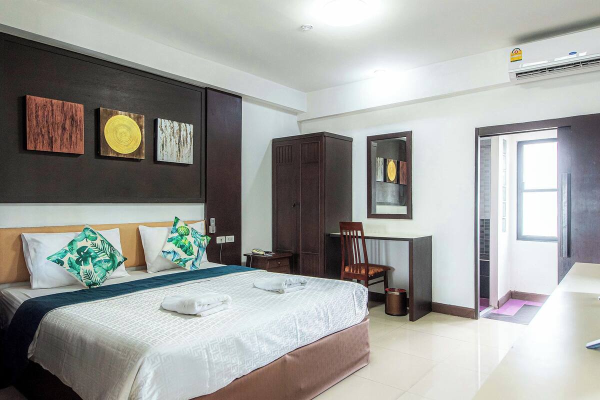 Ein Hotelzimmer mit Bett, Schreibtisch, Stuhl und Kleiderschrank.