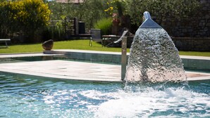 A swimming pool with a water fountain feature.