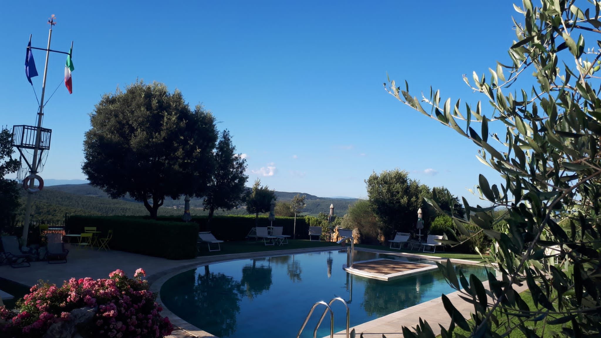 Una piscina con vistas despejadas del paisaje circundante, incluyendo árboles y colinas lejanas.