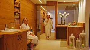 Een spa-ruimte met houten wanden, een receptiebalie en een zithoek.