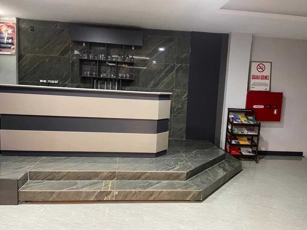 A reception area with a counter, a fire extinguisher, and a no smoking sign.