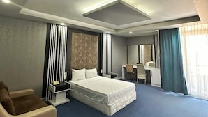 Una habitación de hotel moderna con una cama grande, un escritorio y una silla.