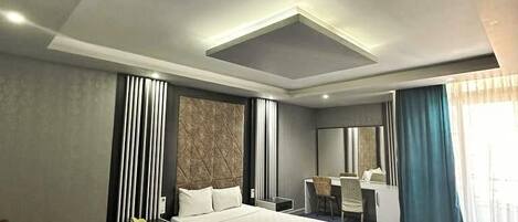 A modern hotel room with a large bed, a desk, and a chair.