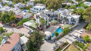 Un hôtel comprenant plusieurs bâtiments, une piscine et des panneaux solaires.