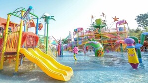Parque acuático con toboganes, estructuras de juego y una máquina de olas.