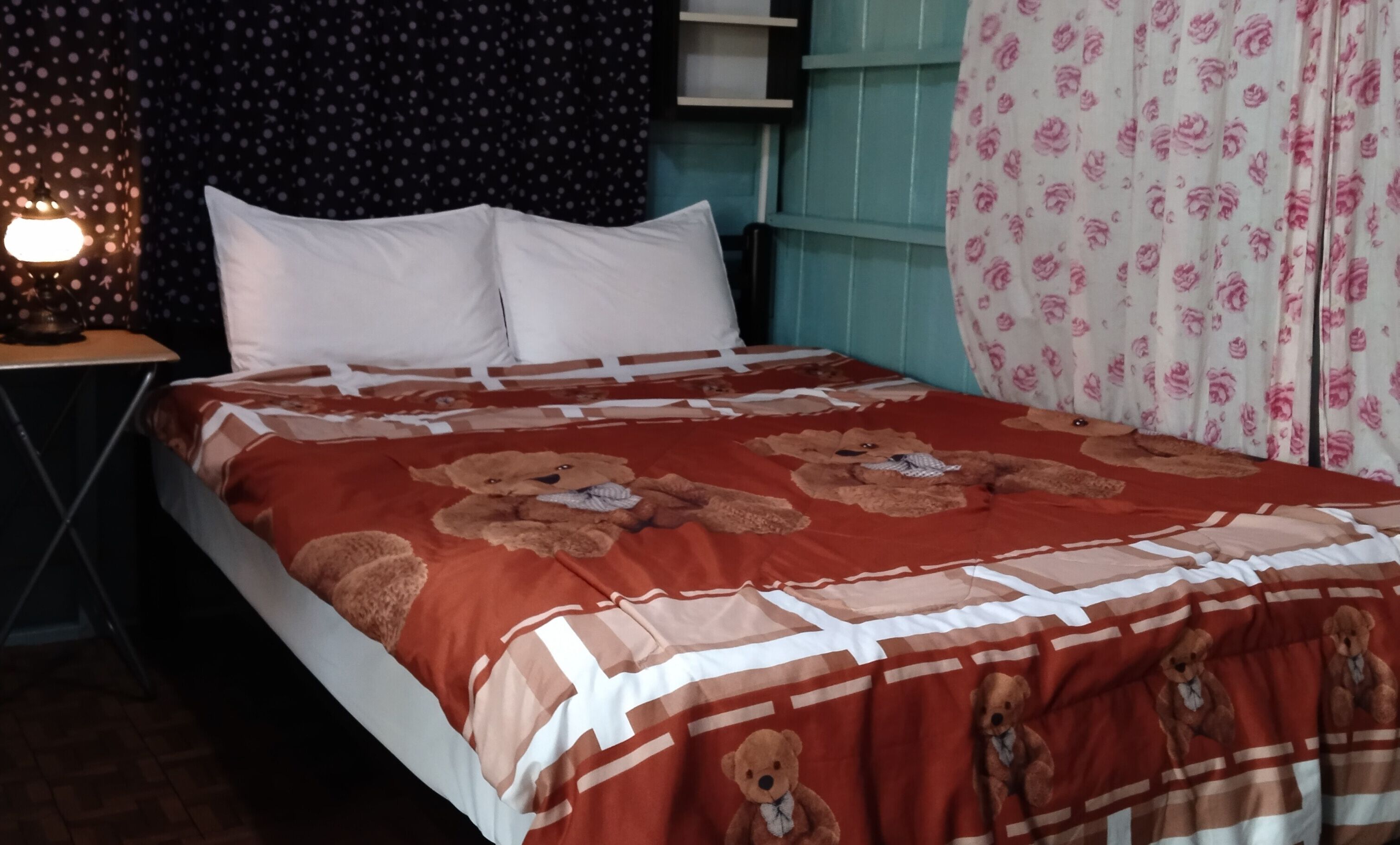 Una cama con un edredón blanco y rojo a rayas y muchas almohadas.