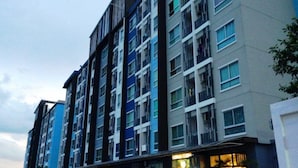 A multi-story residential building with a modern design, featuring balconies and large windows. - The Kith Condo Garden View (Lam Luk Ka)