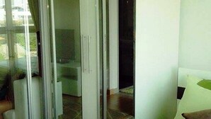 A room with a sliding glass door leading to a balcony. - The Kith Condo Garden View (Lam Luk Ka)