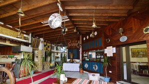 A restaurant with wooden beams, a red carpet, and a bar area. - Sevin Hotel (Bodrum)