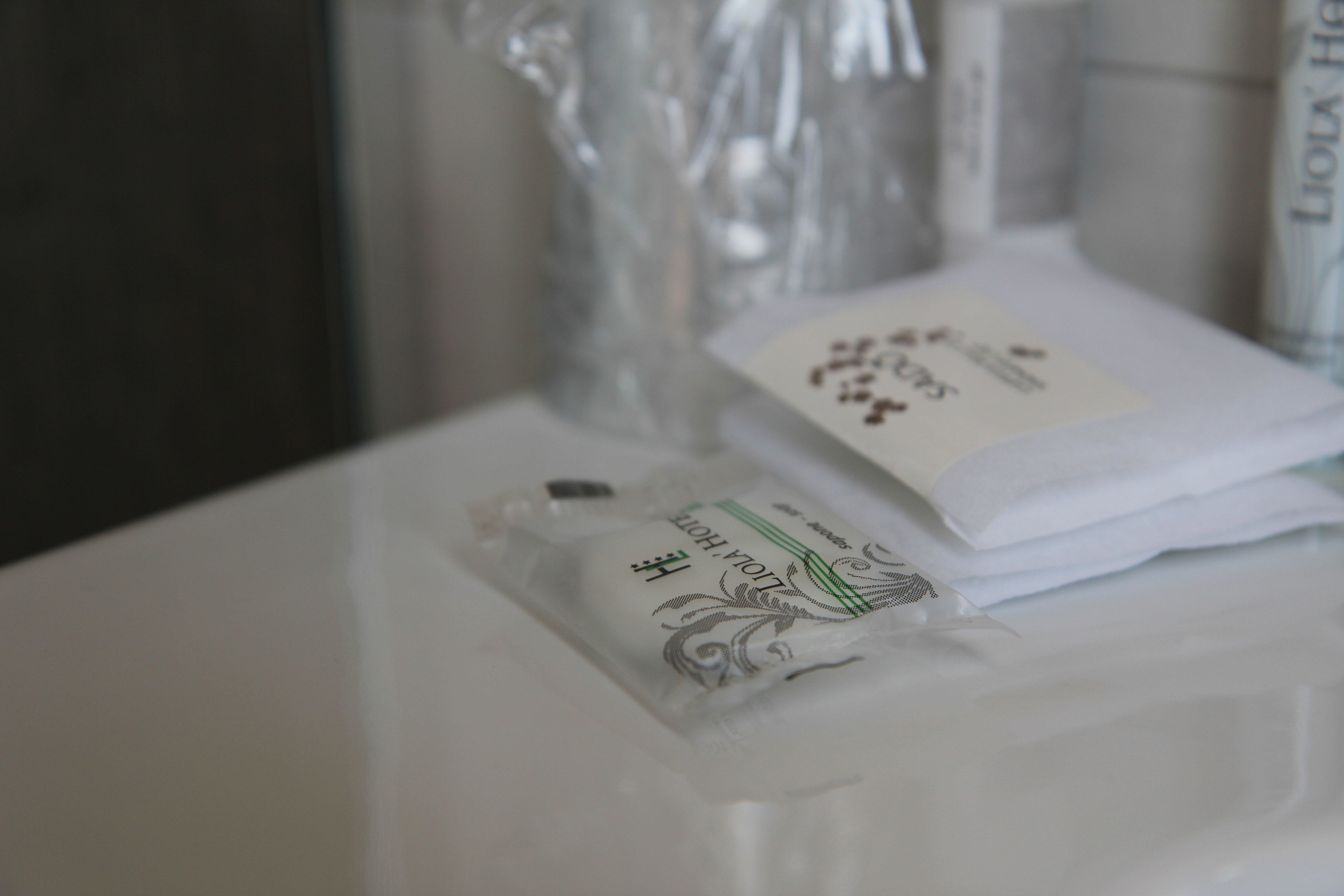 A white plastic container with a label, possibly containing toiletries, on a white surface.