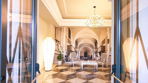 A grand lobby with a checkered floor, elegant chairs, a chandelier, and a large white sculpture. - Suites&Apartments Liolà (Castrocielo)