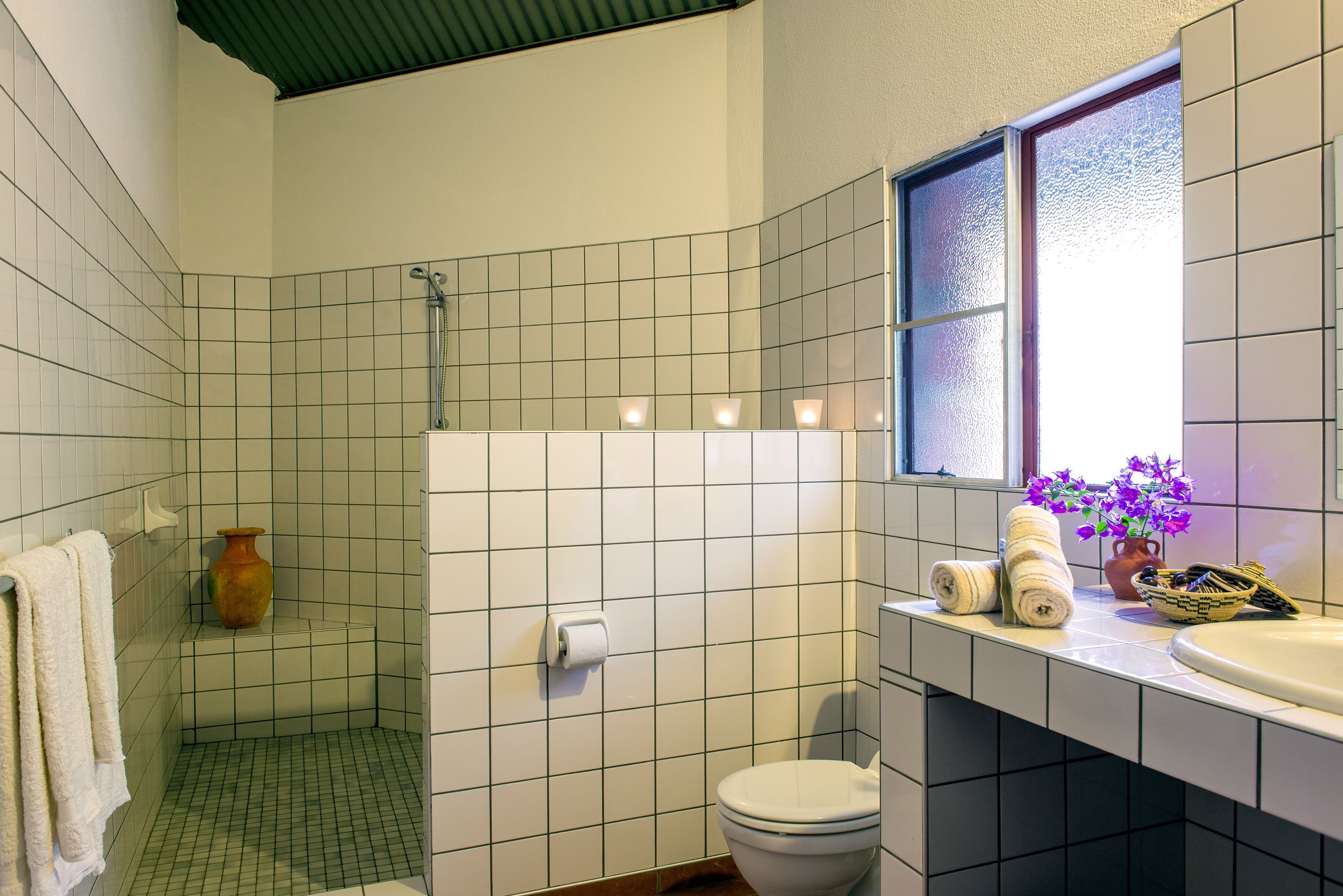 A bathroom with a shower, toilet, and sink.