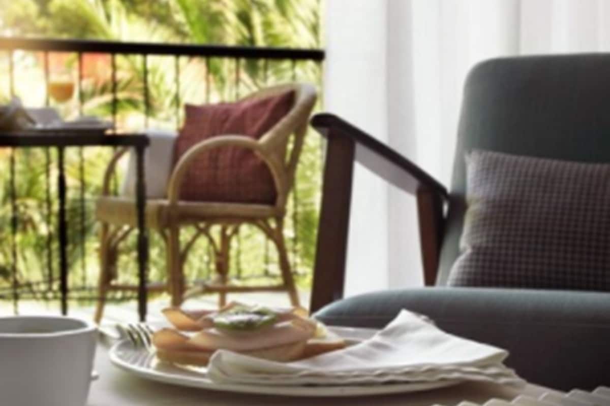 A dining area with a table set for breakfast, including a plate of food, a cup, and a chair.
