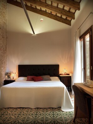 Cozy retreat with a large bed, nightstands, and sloped ceiling.
